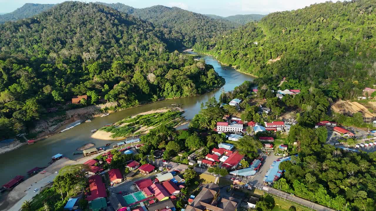 Scenic aerial view of Kuala Tahan town nestled by the Tembeling River, surrounded by lush rainforest near Malaysia’s Taman Negara National Park.