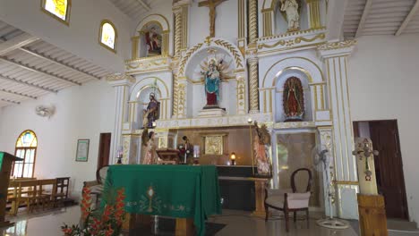 a serene interior view of the church of minca in colombia with vibrant decor and altar setup