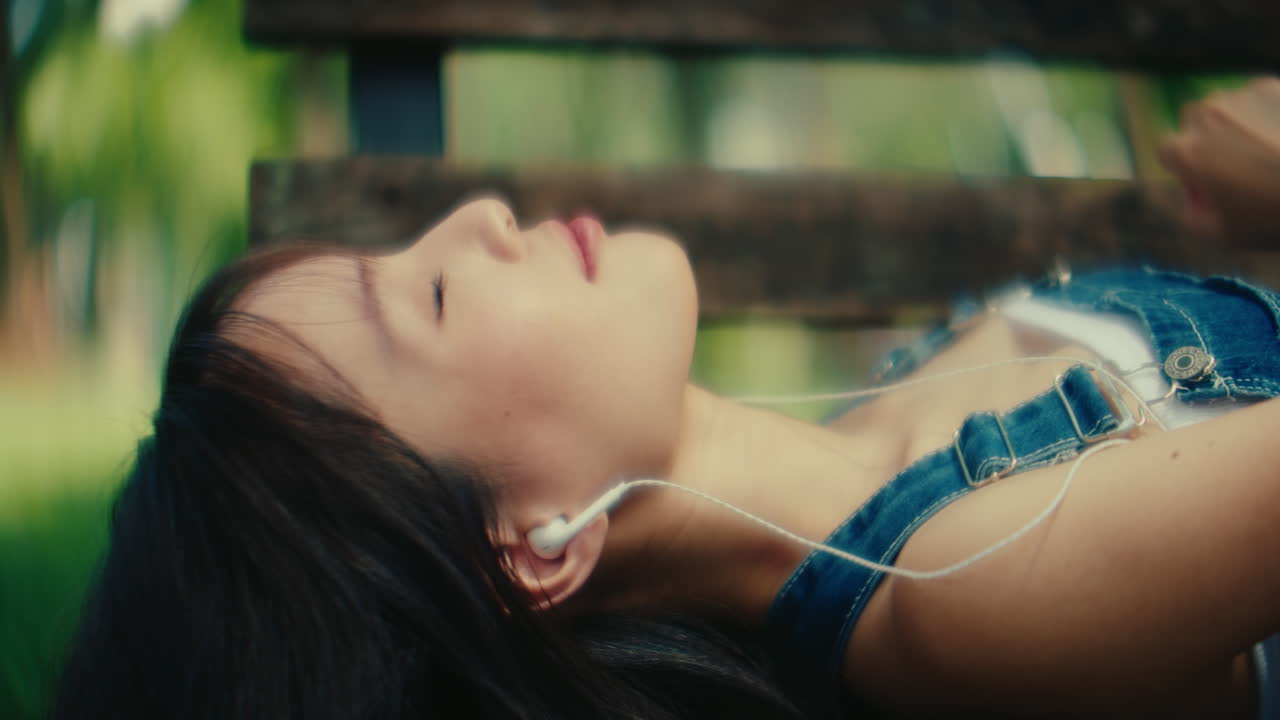 Young woman relaxing in a park listening to music