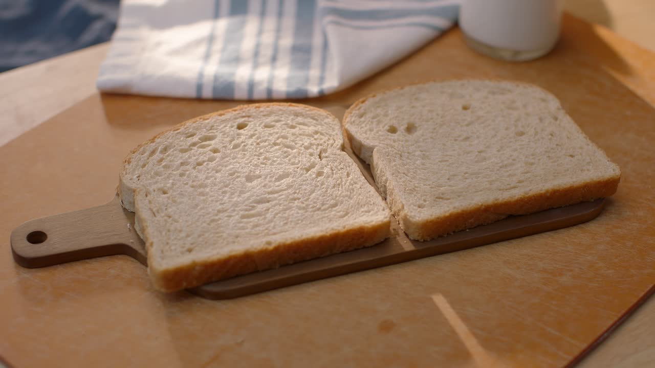 Peanut butter is put on some bread
