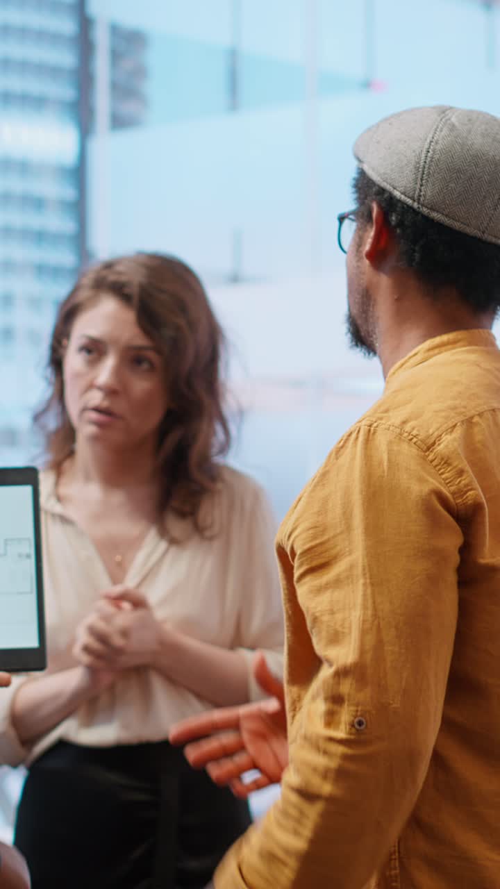 Diverse Business Team Discussing Floor Plan on Digital Tablet