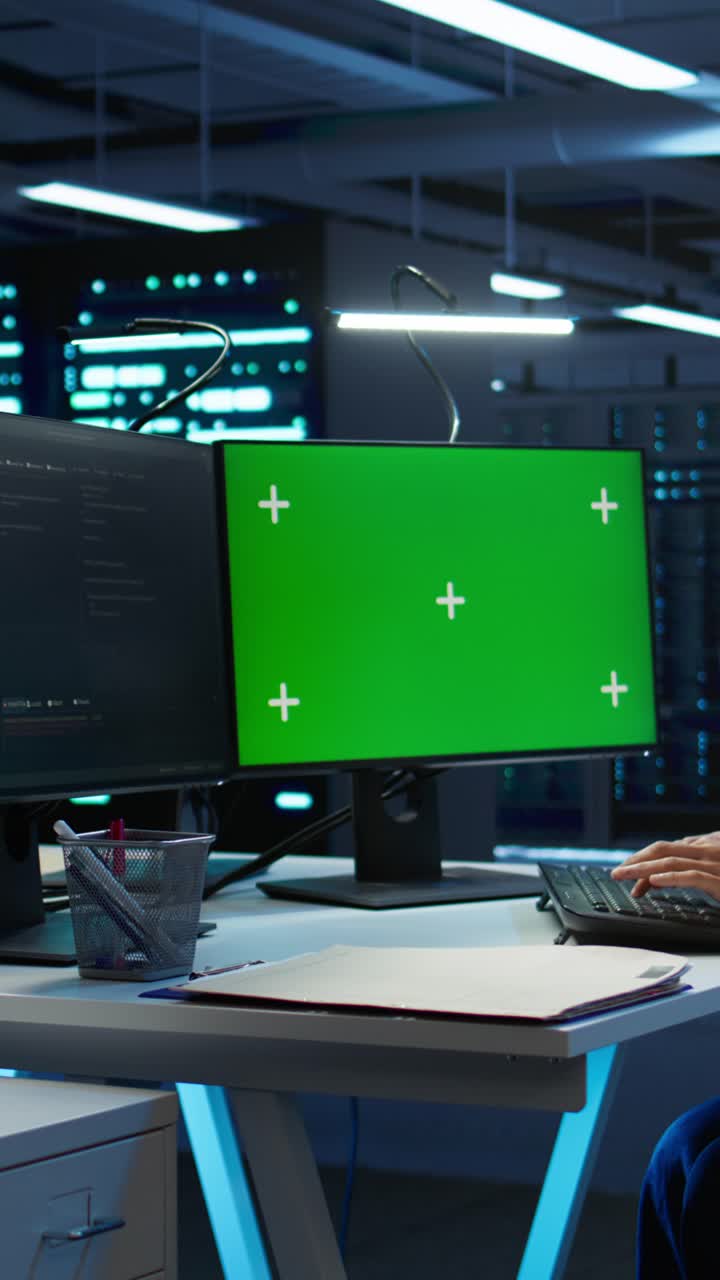 Person, der skriver på tastatur med grøn skærm i datacenter