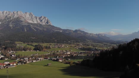 aerial: flying over a valley of the alps with high mountains in the back