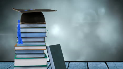 animation of stack of books with graduation hat on top over glowing lights