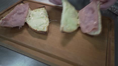 colocando sándwiches abiertos con queso derretido y jamón