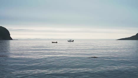 Dos-Barcos-Flotando-En-El-Mar-Con-Olas-Tranquilas-En-Flakstadvag,-Noruega.