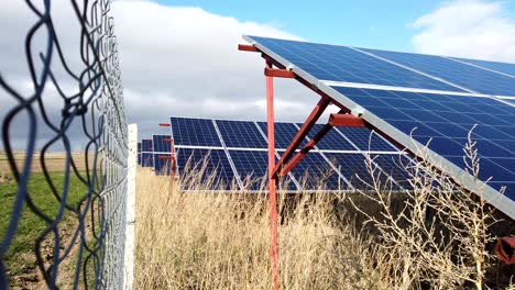 Paneles-Solares-Detrás-De-La-Cerca-En-Un-Clima-Ventoso