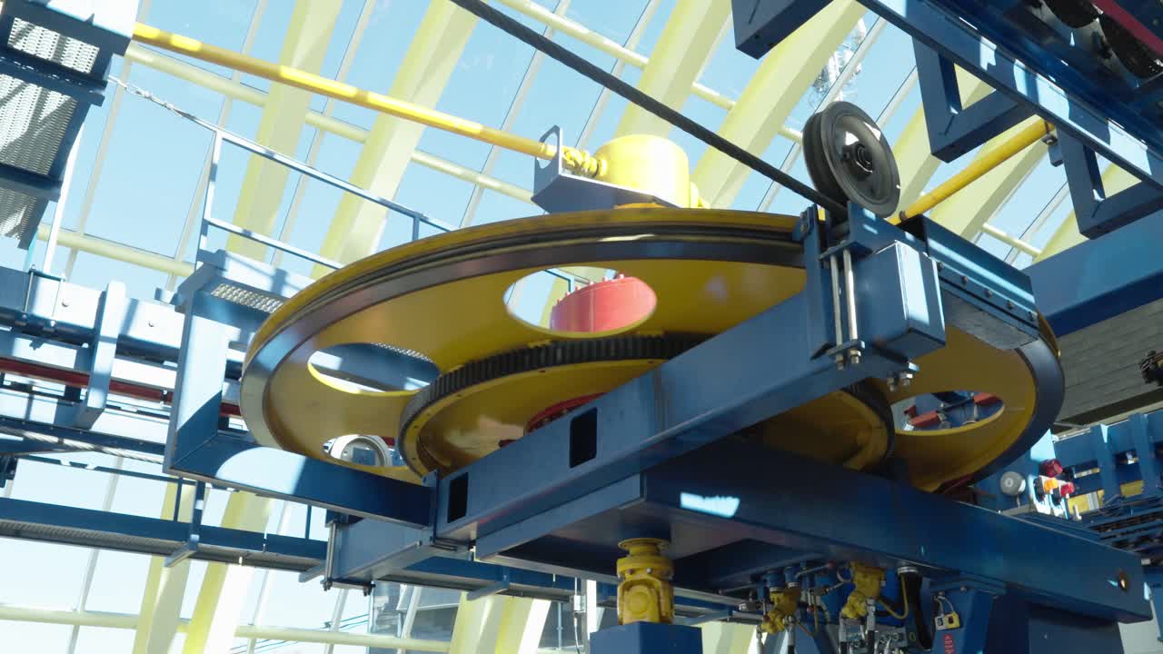 Close-up of gondola lift technology with large rotating wheel and mechanical parts inside a modern station. Concept of engineering, transport, and mountain infrastructure