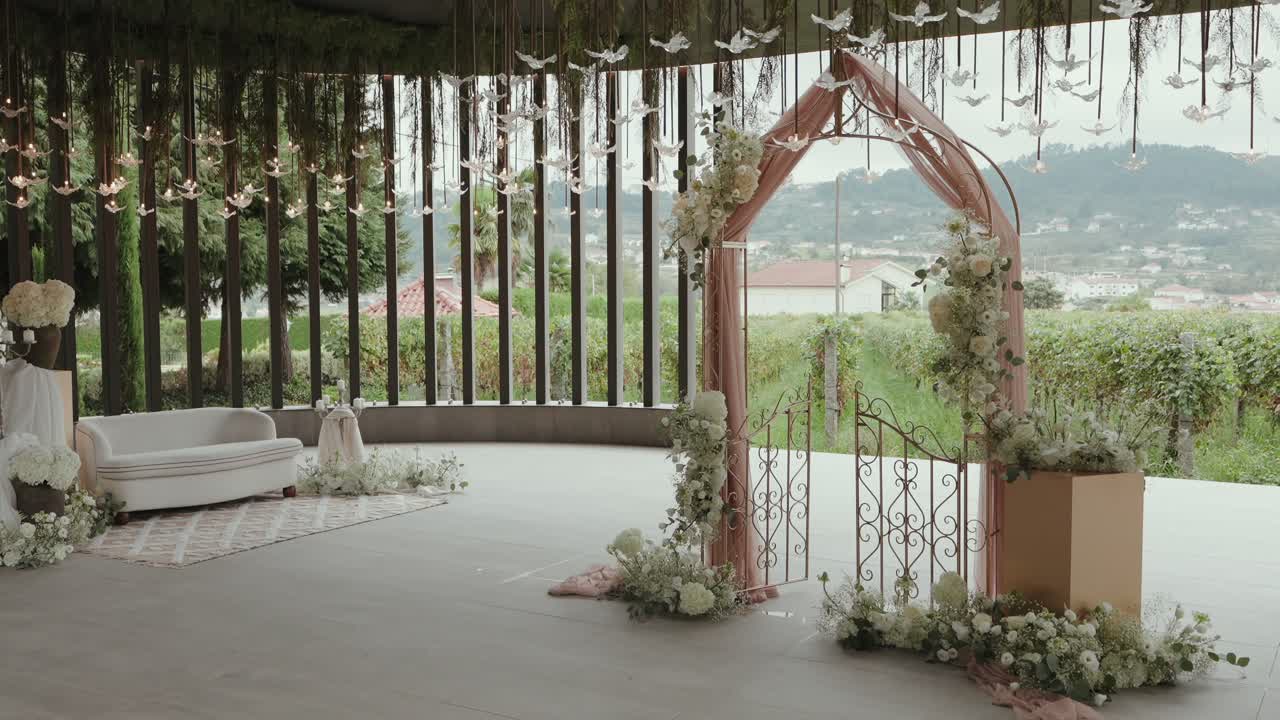 밝고 탁 트인 야외 장소에 놓인 우아한 플로럴 웨딩 아치 세트