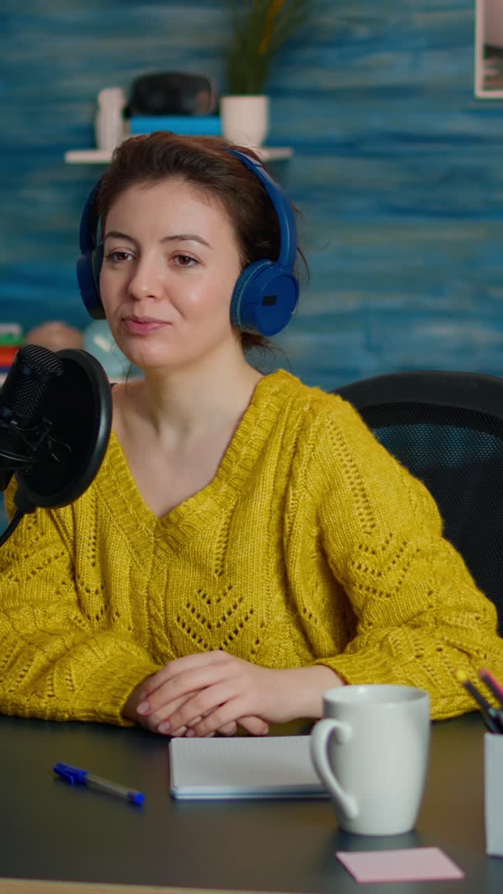 Vertical video: Blogger speaking about life during podcast in home studio