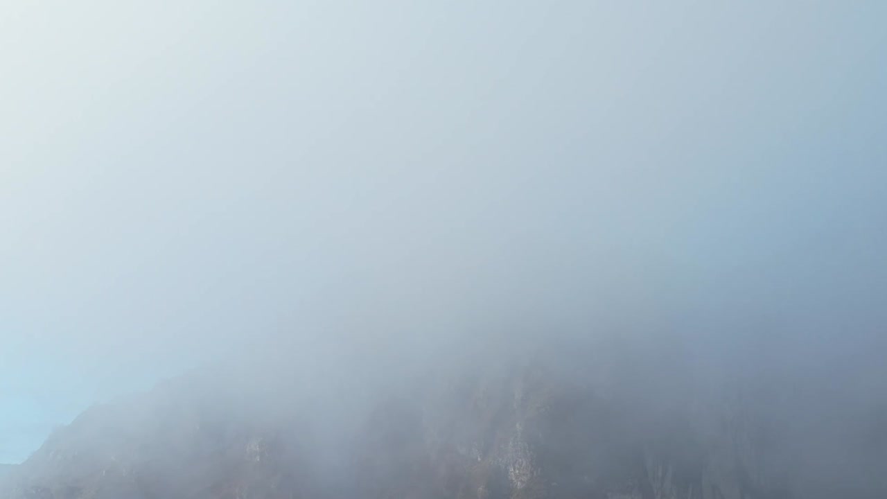 Stunning aerial view of the Alps in Italy with mist and blue sky