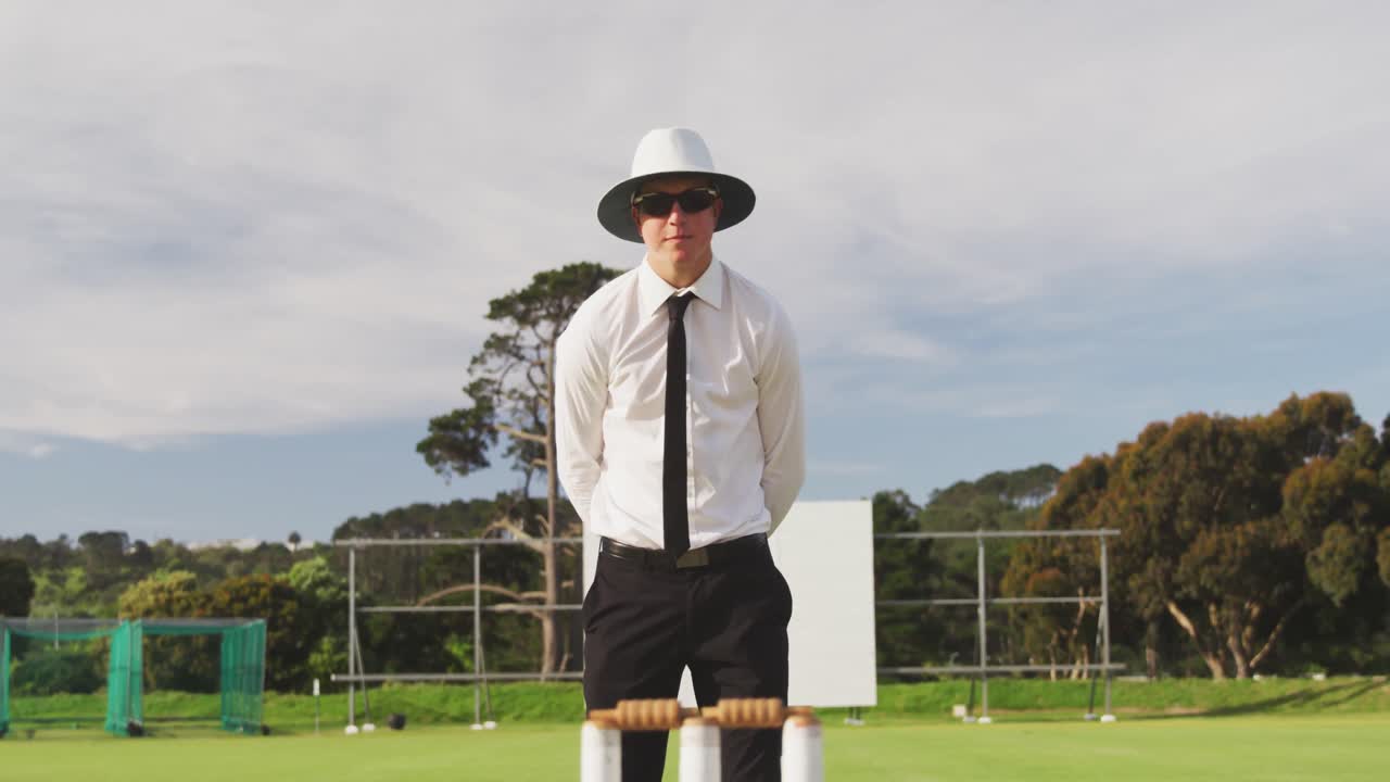 크리켓 피치 에 서 있는 신호 를 만드는 크리켓 심판