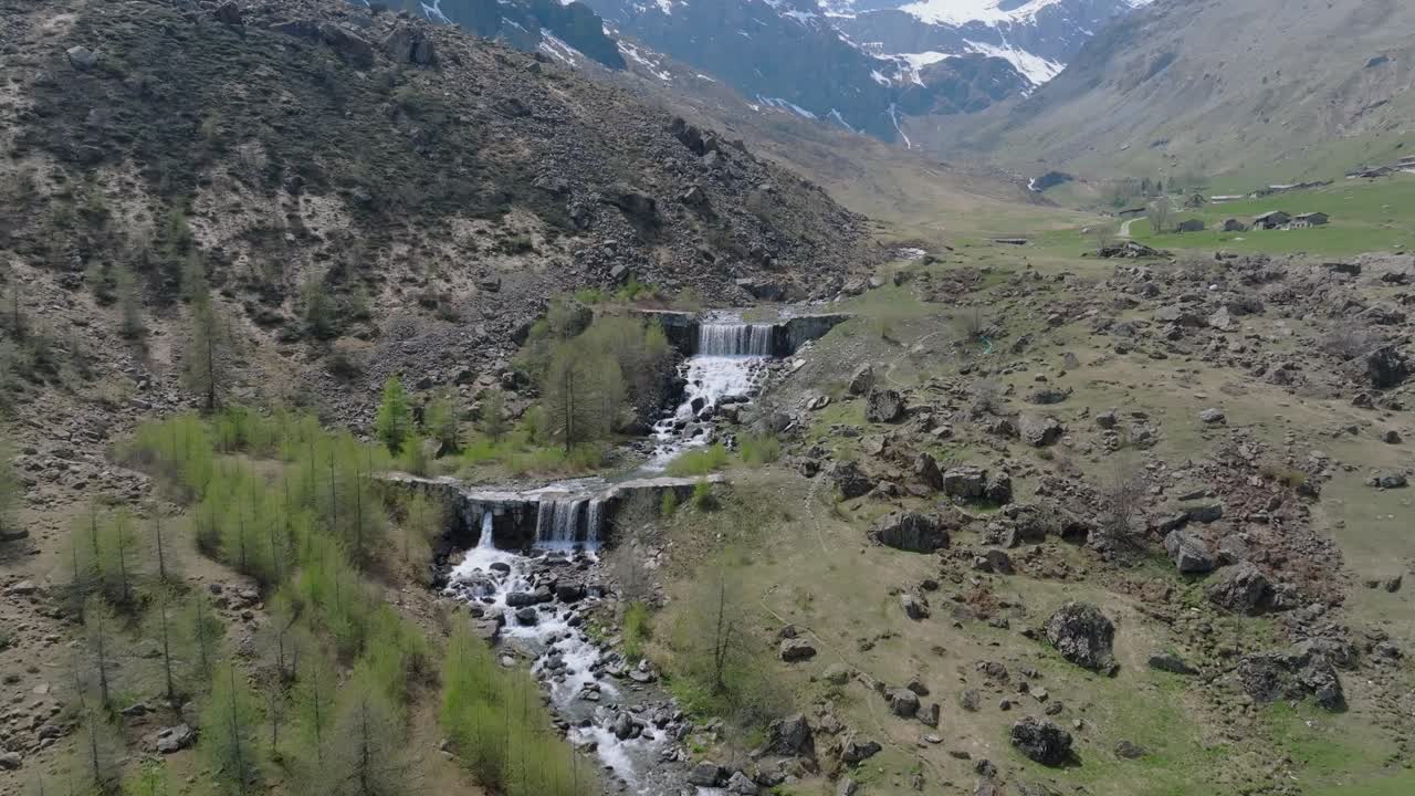 Beautiful aerial footage of a freshwater stream flowing through the scenic Po Valley in Italy, surrounded by majestic mountains