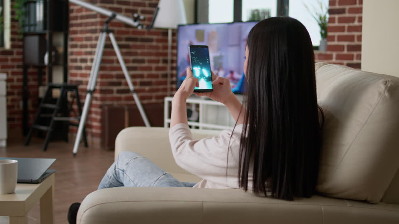 Woman using her mobile phone at home