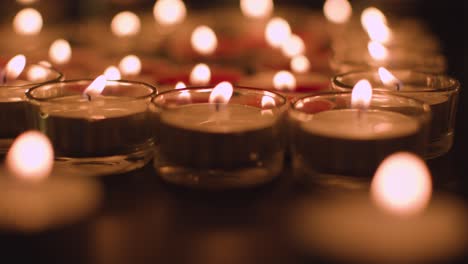 close up shot of romantic red and white candles in the shape of a heart on black background