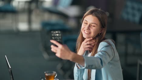 Bella-Joven-Tomando-Un-Selfie-Por-Teléfono-En-Un-Café