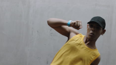 hombre bailarín joven bailarín de calle feliz realizando varios movimientos de baile de estilo libre adecuado hombre de raza mixta practicando en un almacén grungy con chaleco amarillo de cerca