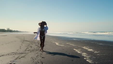 woman walking on a beach at sunrise