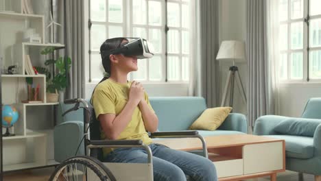 scary asian kid girl sitting in a wheelchair while wearing virtual reality goggles watching horror movie at home