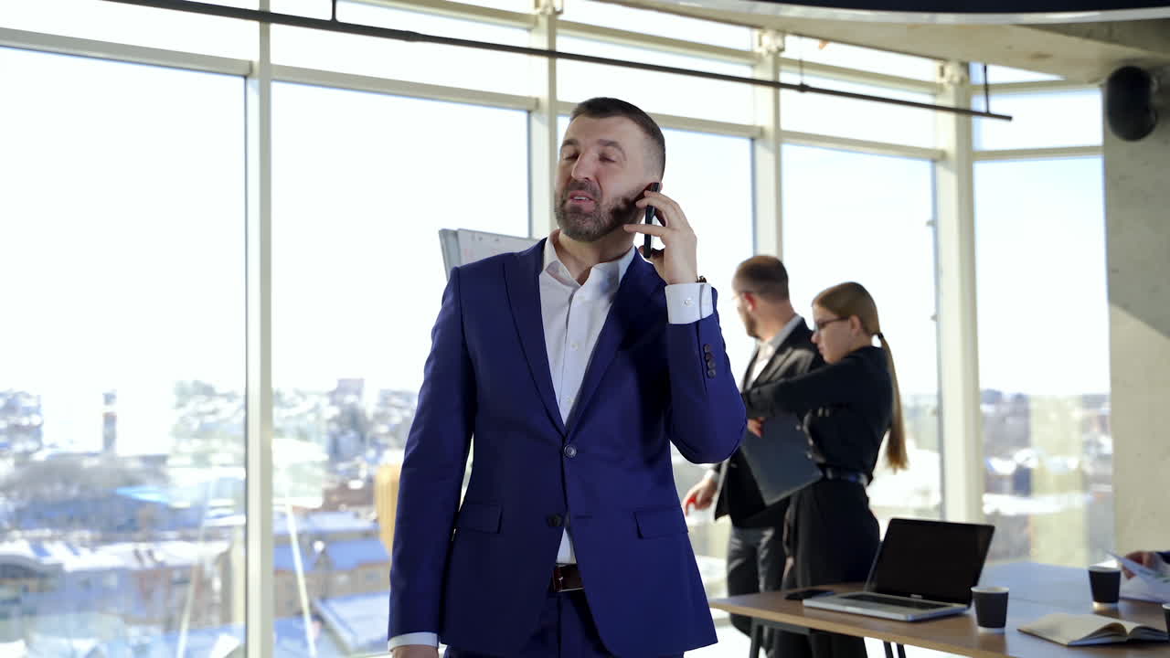 Happy businessman having a phone conversation. Partners working in office centre developing new strategies. Business people in the company.