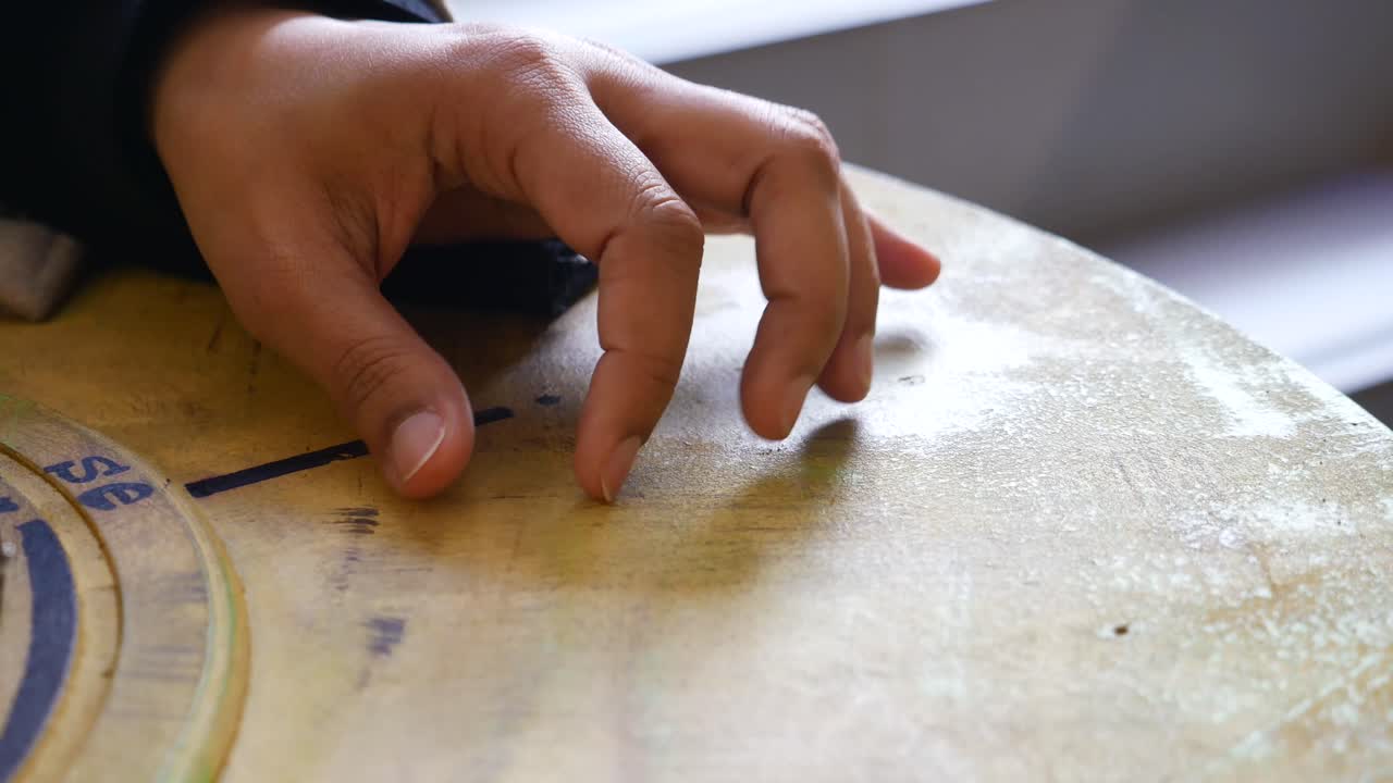 Close-up of a hand touching a wooden table