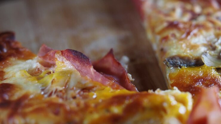 Primo piano di una deliziosa fetta di pizza con prosciutto e formaggio