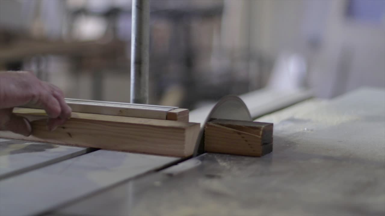 cortar un tablón de madera con una sierra eléctrica en cámara lenta