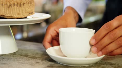 male owner serving coffee to customers