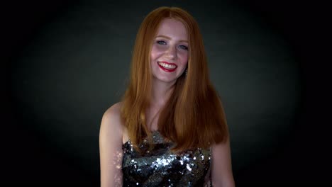 a young beautiful woman in shimmery dress ,all happy and joyous, laughing and smiling looking towards the camera