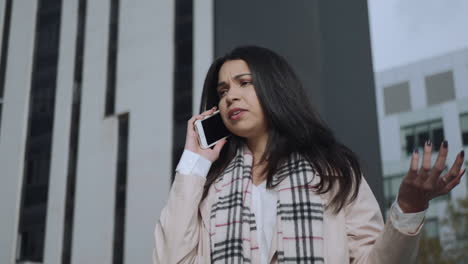 businesswoman talking mobile phone at city street. lady arguing on phone