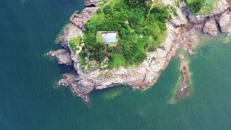 camping edge of rugged shoreline on island tung lung chau, aerial