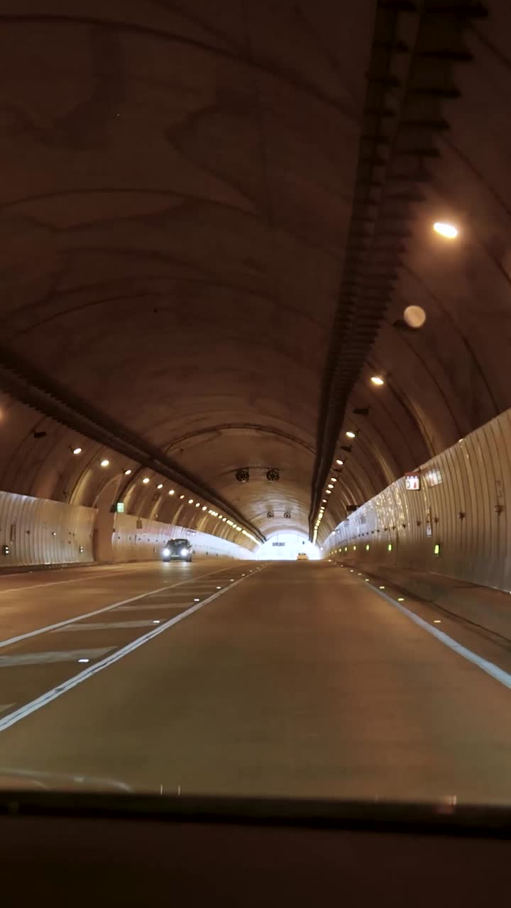 Punto di vista alla guida all'interno di una galleria stradale ben illuminata