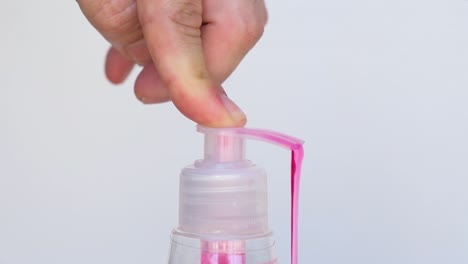 Pressing-the-bottle-of-red-liquid-hand-soap