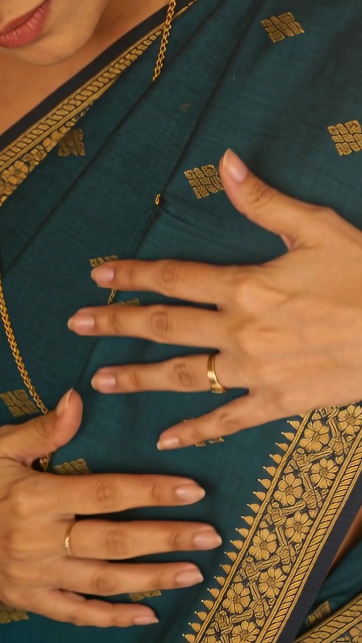 Video verticale: Donna indiana che si prepara, allacciando un sari verde acqua a casa e lisciando una catena d'oro.