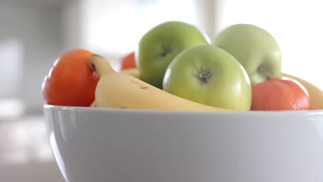 close up of fruit in white bowl on countertop in kitchen