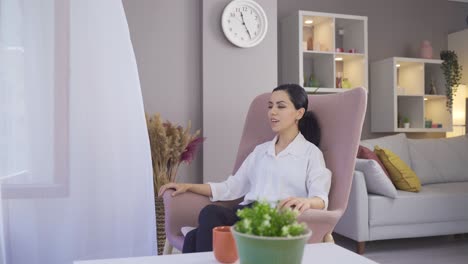 Mujer-Sentada-En-Un-Sillón-En-Casa-Descansando,-Respirando-Y-Sonriendo.