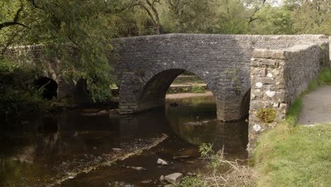 disparo medio del puente de piedra en el molino de wetton sobre el río