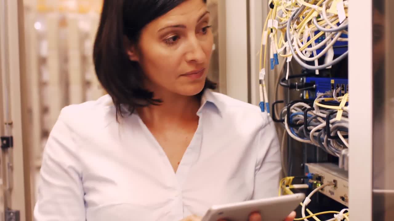 Technician checking cables in a rack mounted server