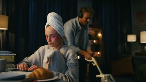 nervous girl feeling disturbed workplace closeup. headphones husband vacuuming