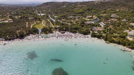 aerial view of a crowded turquoise beach on a sunny day