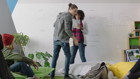 Joven-Mujer-De-Negocios-Afroamericana-Enseñando-A-Un-Grupo-De-Estudiantes-Mostrando-El-Cronograma-Del-Proyecto-En-Una-Pizarra-Presentando-Datos-Gráficos-Equipo-Diverso-Intercambiando-Ideas-En-Una-Conferencia-De-Oficina