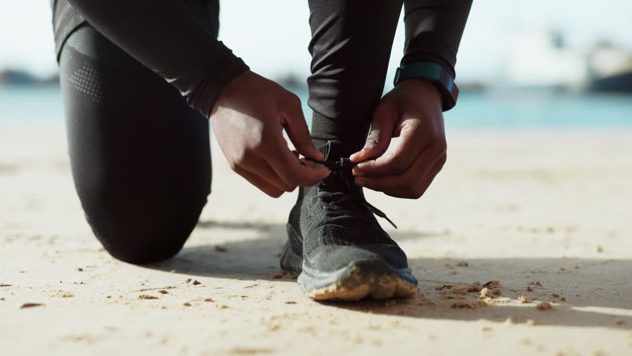 manos, zapatos y corbata con un hombre en la playa