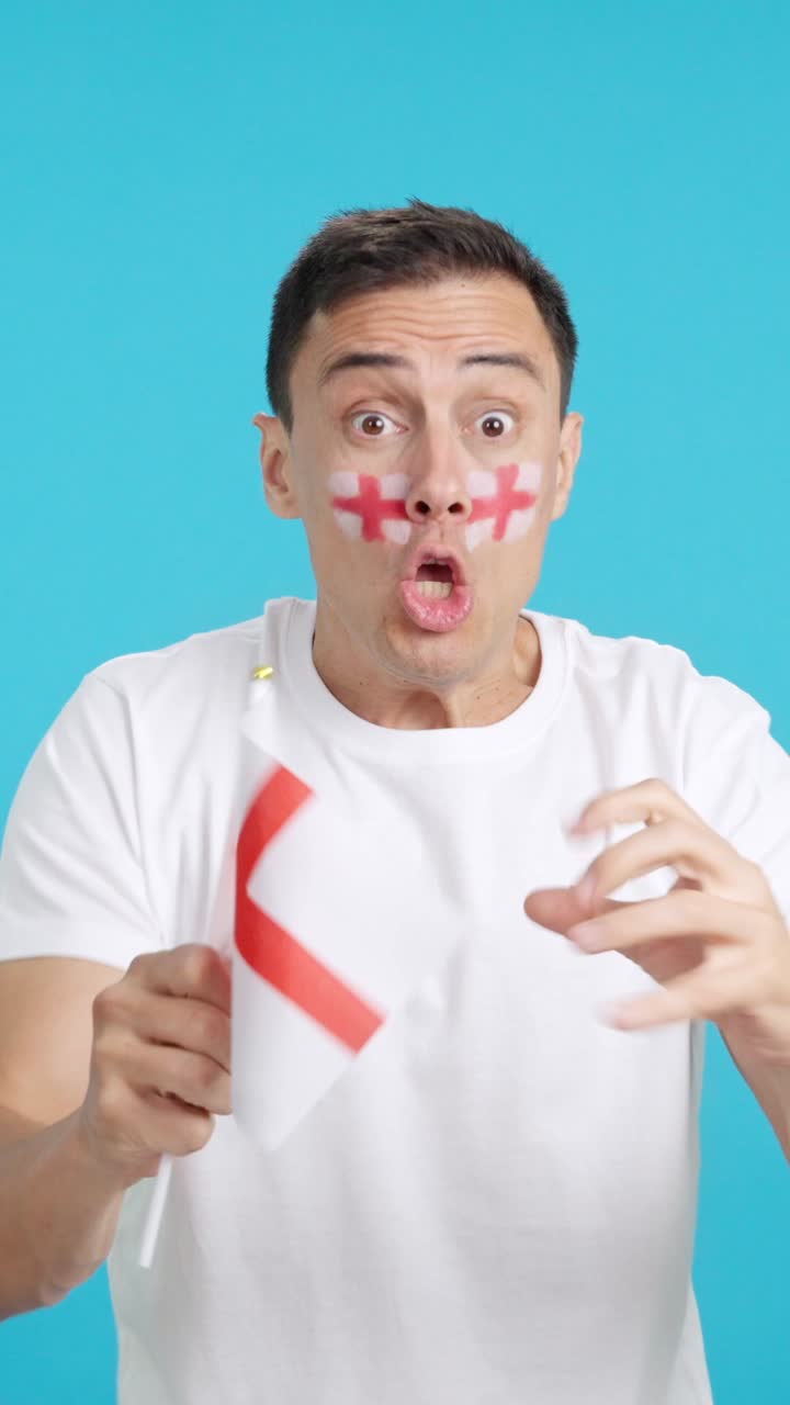 Passionate english supporter screaming and waving a national flag