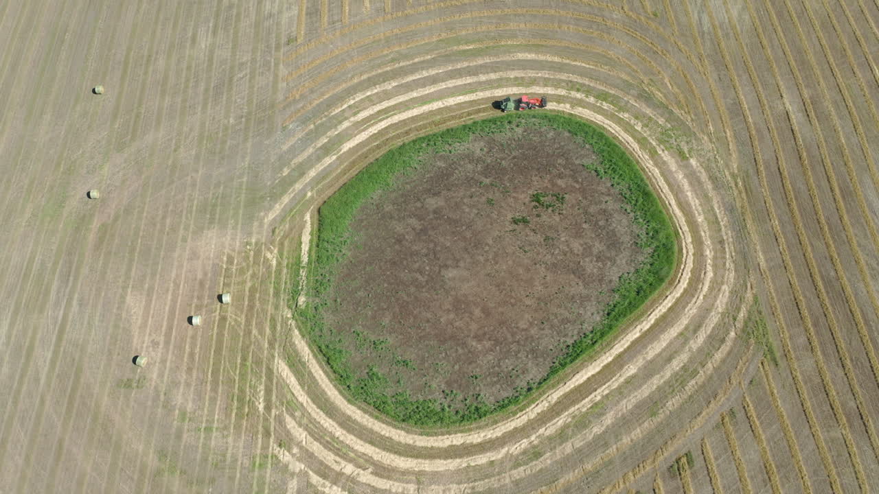 화창한 날 캐나다 서스캐처원의 들판에서 건초를 묶는 건초 포장기의 조감도 - 공중