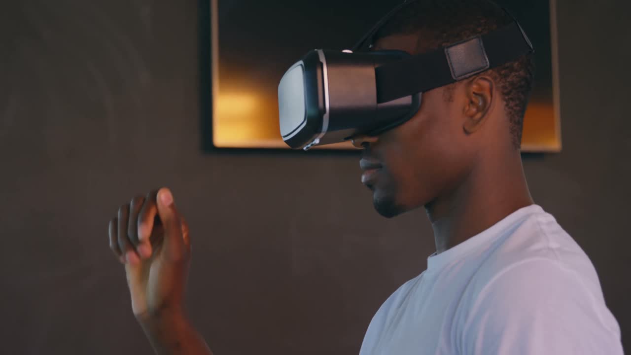 Side view of young black male executive using virtual reality headset at desk in modern office 4k