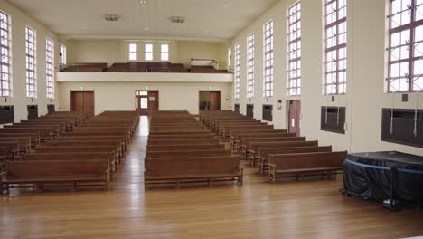 old fashioned school auditorium, wooden flooring and benches