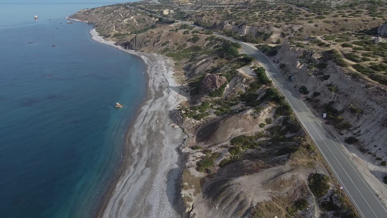 Wide aerial view of an empty beach due to quarantine during the COVID-19 pandemic ast the normally popular attraction of Aphrodite's Rock in Cyprus.