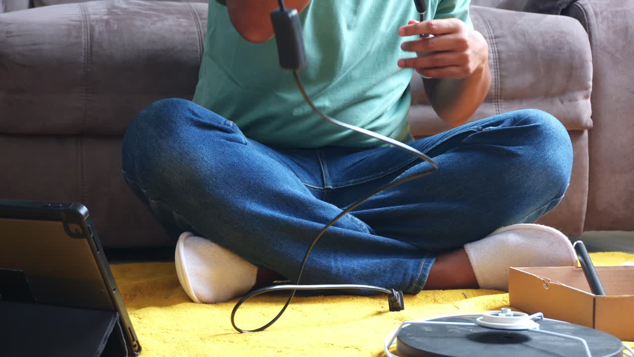 Man assembling new lamp carefully while checking electric cord and consulting instructions at home