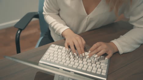 manos femeninas escribiendo en el teclado del portátil