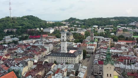 rynok square in lviv ukraine with the ukrainian flag flying on top of a tower in city hall surrounded by old european buildings
